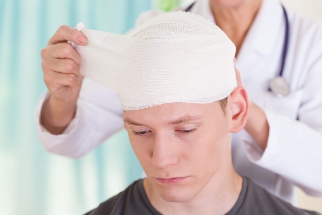 A man getting his dressing changed by a doctor after a traumatic brain injury